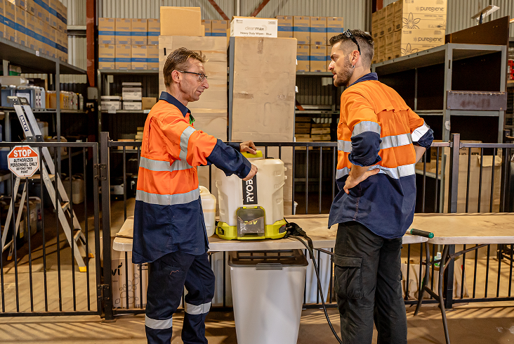 Two Kestrel Cleaning Services team members preparing cleaning equipment in a Port Hedland warehouse