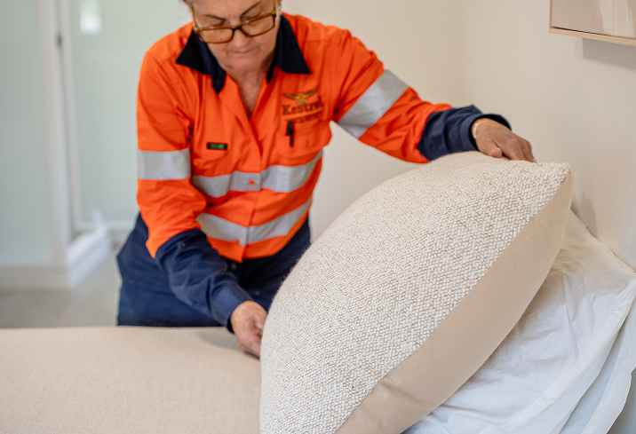 Kestrel Cleaning team member adjusting a cushion during a professional home cleaning service